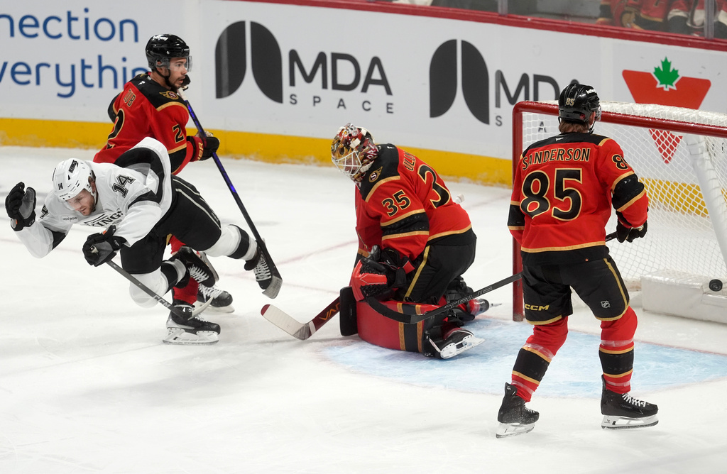 Ottawa Senators defensemen Jake Sanderson (85) and Artem Zub (2) look on as Los Angeles Kings right wing Alex Laferriere (14) celebrates his goal on goaltender Linus Ullmark (35) as he falls to the ice during the first period of an NHL hockey game in Ottawa, Ontario, Saturday, Nov. 15, 2025. (Adrian Wyld/The Canadian Press via AP)