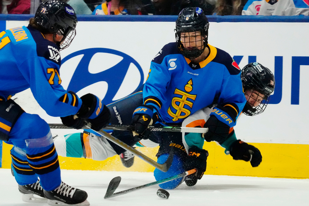 Toronto Sceptres' Kali Flanagan (centre) checks New York Sirens' Maddi Wheeler (18) as Sceptres' Anna Kjellbin (71) looks on during the third period of an PWHL hockey game in Toronto on Tuesday, April 21, 2026. (Frank Gunn/The Canadian Press via AP)