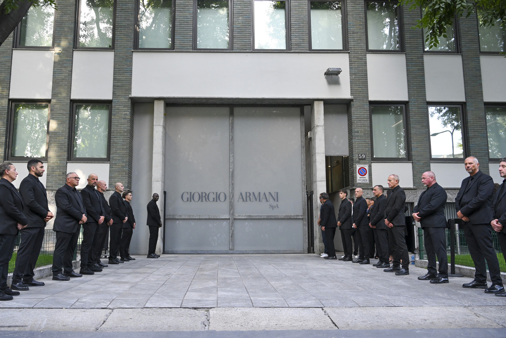 Staff of Giorgio Armani Spa gather outside the Armani/Teatro in Milan, northern Italy, to pay their respects to designer Giorgio Armani, who died Thursday at age 91, Sunday, Sept. 7, 2025. (AP Photo/Nicola Marfisi)