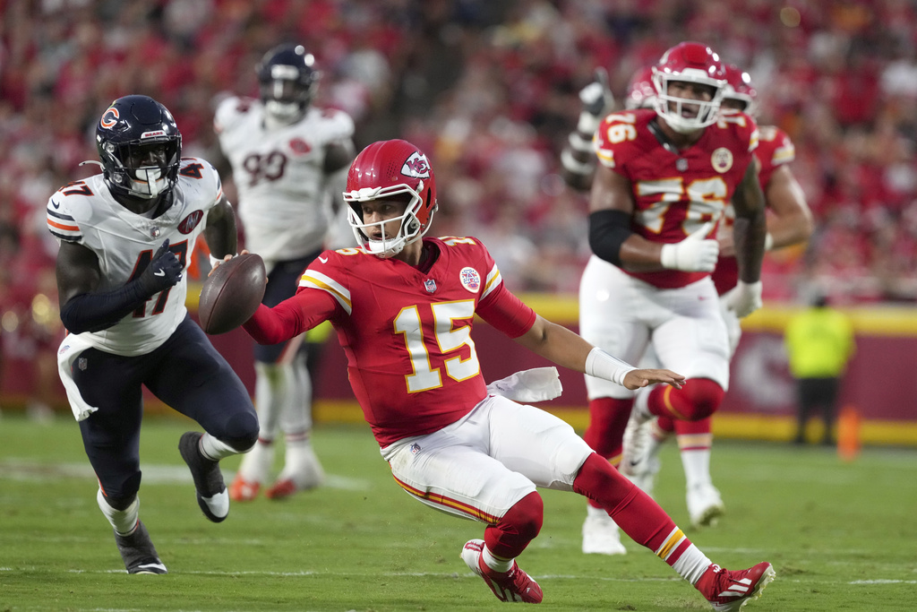 Kansas City Chiefs quarterback Patrick Mahomes (15) scrambles as Chicago Bears linebacker Ruben Hyppolite II (47) defends during the first half of a preseason NFL football game Friday, Aug. 22, 2025, in Kansas City, Mo. (AP Photo/Ed Zurga)