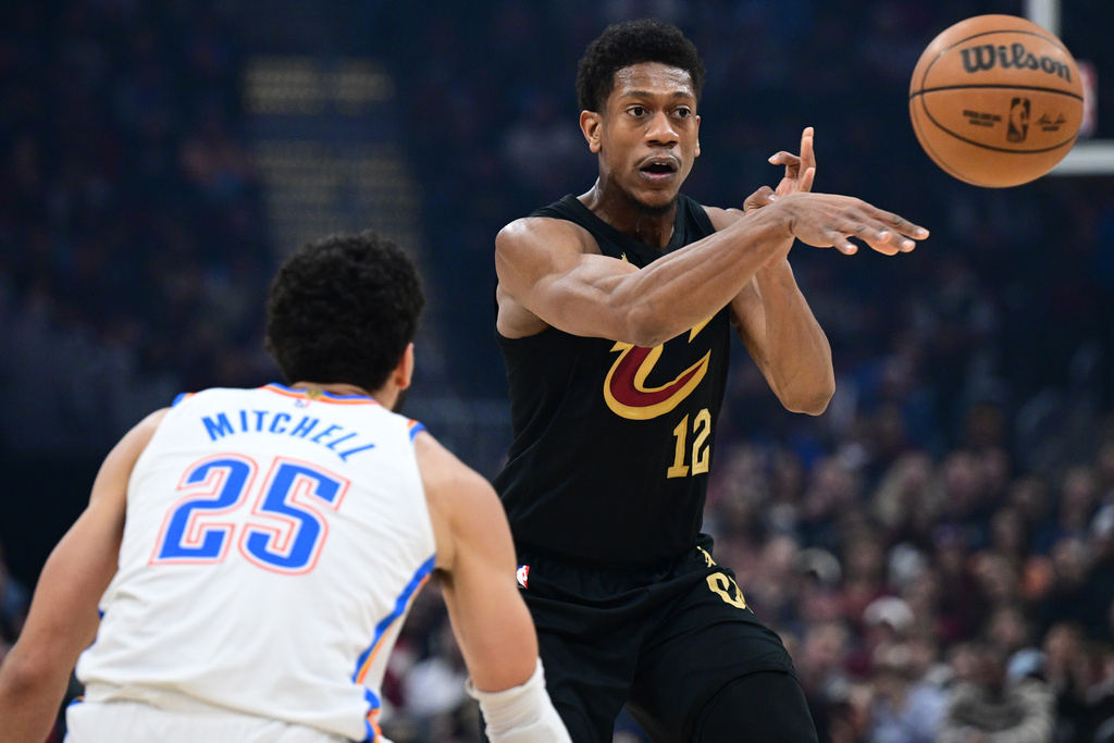 Cleveland Cavaliers forward De'andre Hunter, right, passes the ball against Oklahoma City Thunder guard Ajay Mitchell, left, in the first half of an NBA basketball game, Monday, Jan. 19, 2026, in Cleveland. (AP Photo/David Dermer)