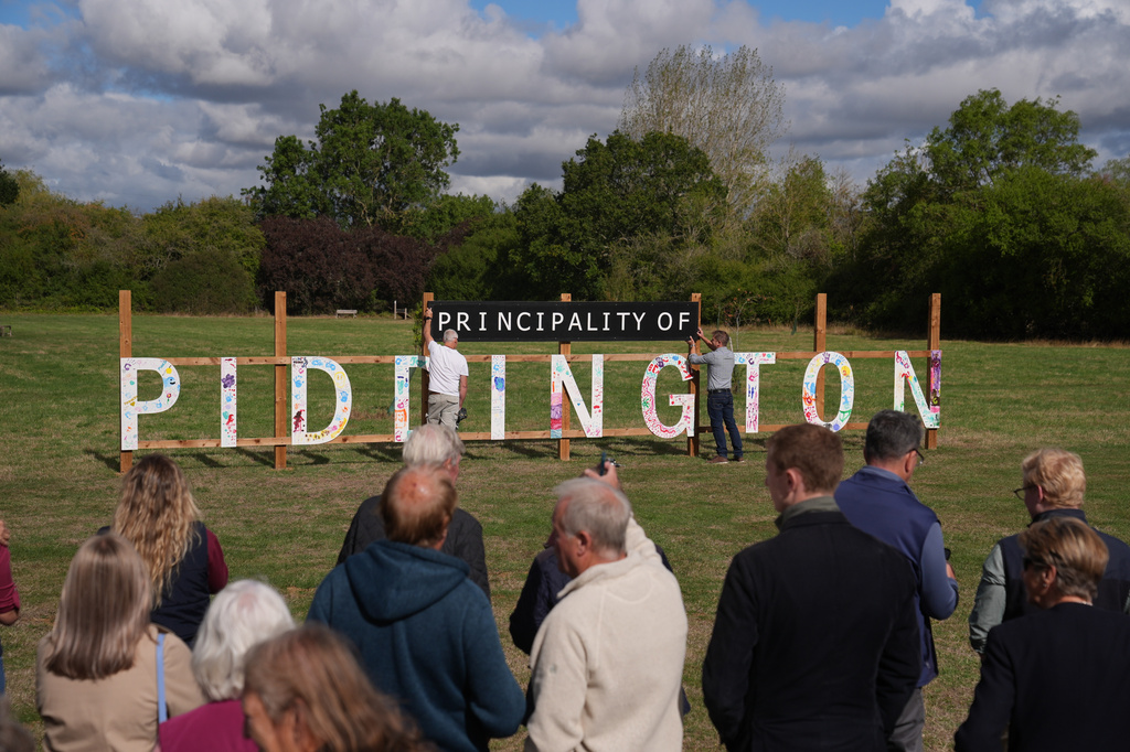 Local residents unveil a "Principality of Piddington" sign in the village of Piddington, Oxfordshire, England, Wednesday, Sept. 16, 2026, after they voted overwhelmingly to become an independent state in a symbolic "referendum". (Joe Giddens/PA via AP)