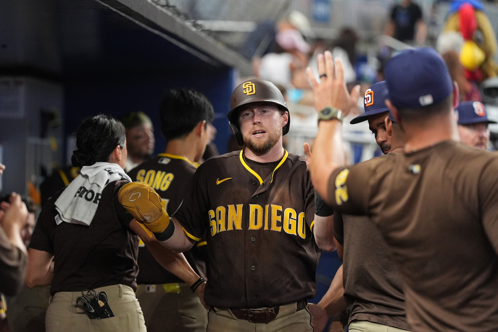 San Diego Padres' Jake Cronenworth celebrates with teammates after scoring on a double by designated hitter Manny Machado during the fifth inning of a baseball game against the Miami Marlins, Sunday, July 26, 2026, in Miami. (AP Photo/Rebecca Blackwell)