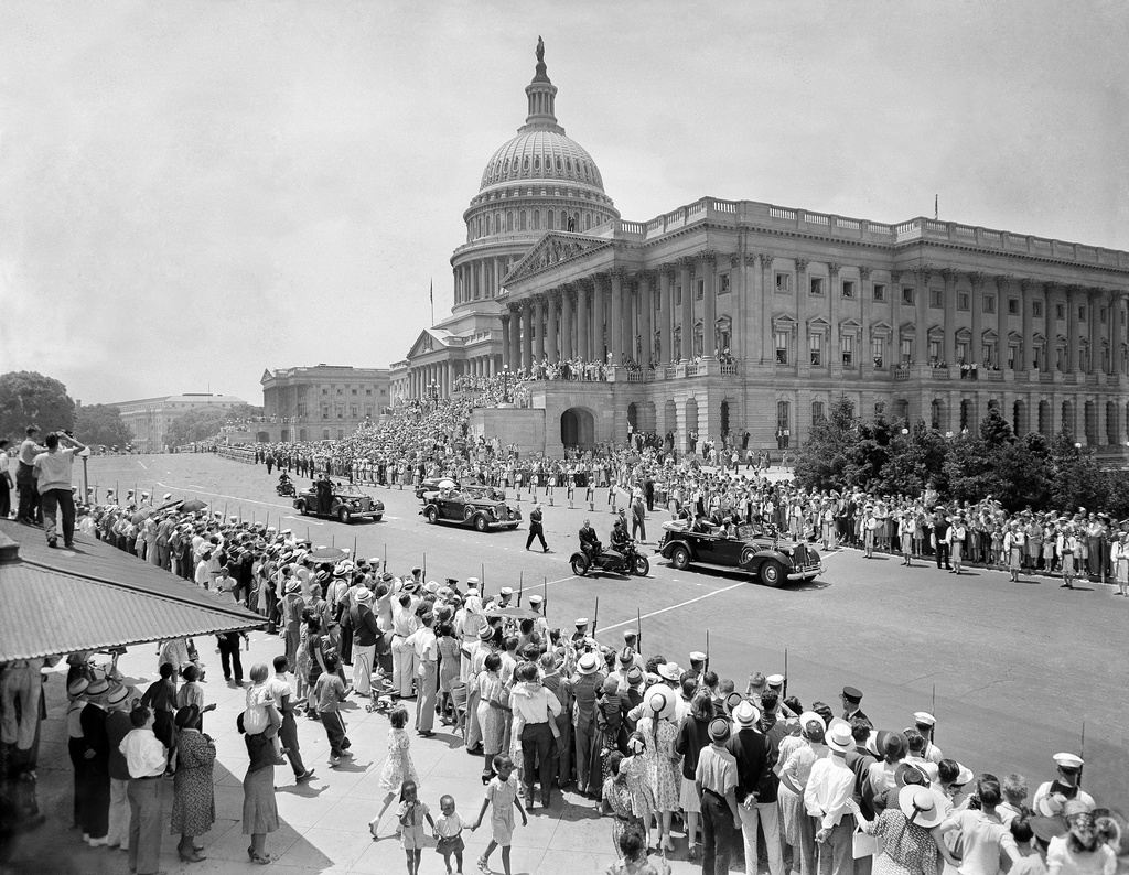 FILE - Cars bearing royalty of England and first family of United States are shown swinging in front of Capitol before they journeyed up Pennsylvania Avenue to White House in parade in Washington, D.C., on June 8, 1939. In car on right, leading the parade, are President Franklin Roosevelt and King George VI. Next car bears Queen Elizabeth and Mrs. Eleanor Roosevelt. Marines line the march. (AP Photo, File)