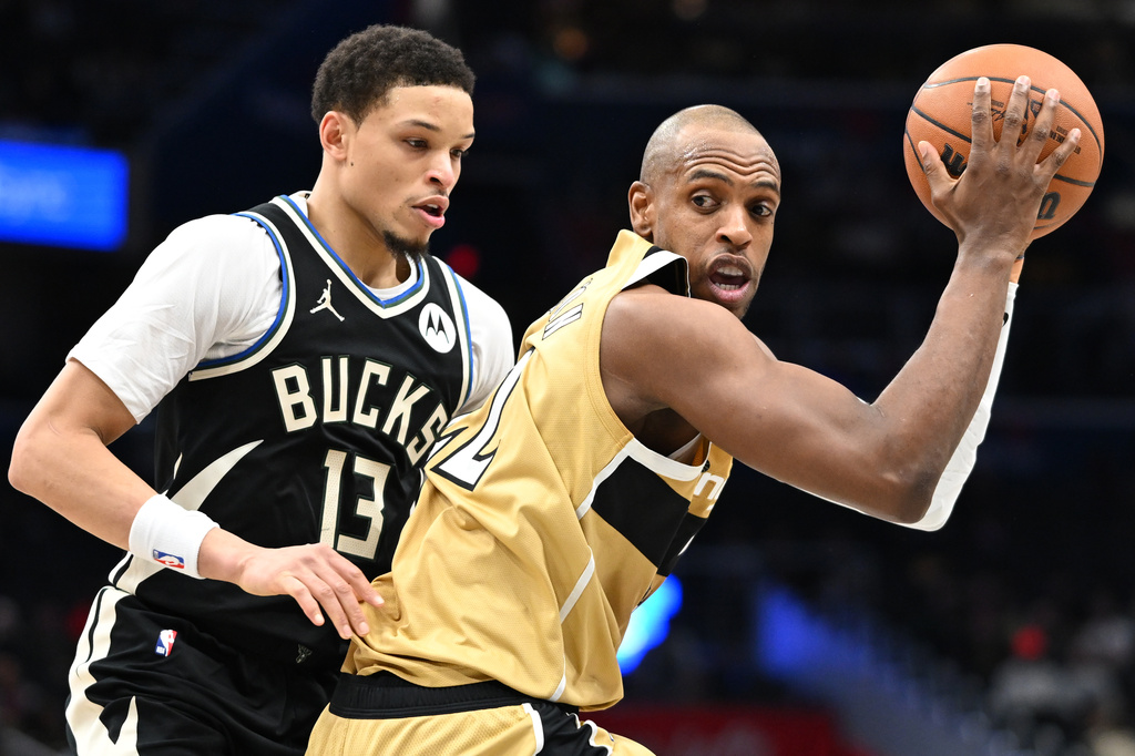 Milwaukee Bucks guard Ryan Rollins (13) guards against Washington Wizards forward Khris Middleton, right, during the first half of an NBA basketball game, Thursday, Jan. 29, 2026, in Washington. (AP Photo/John McDonnell)