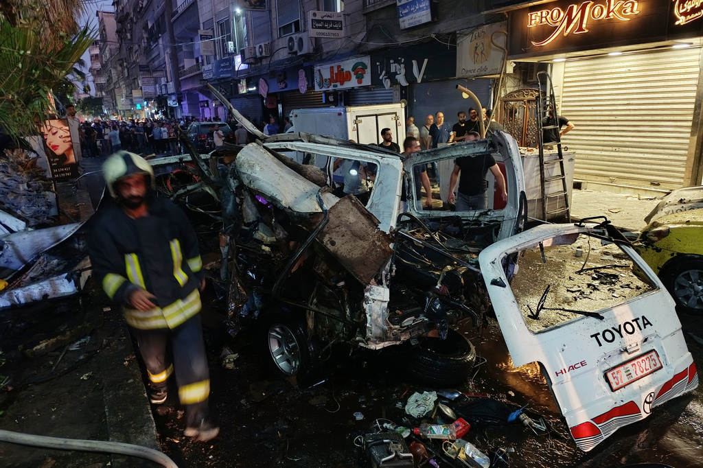 Syrian firefighters and first responders inspect damaged vehicles at the site of an explosion in the Jaramana suburb of Damascus, Syria, Thursday, Aug. 6, 2026. (AP Photo/Abdulrahman Shaheen)