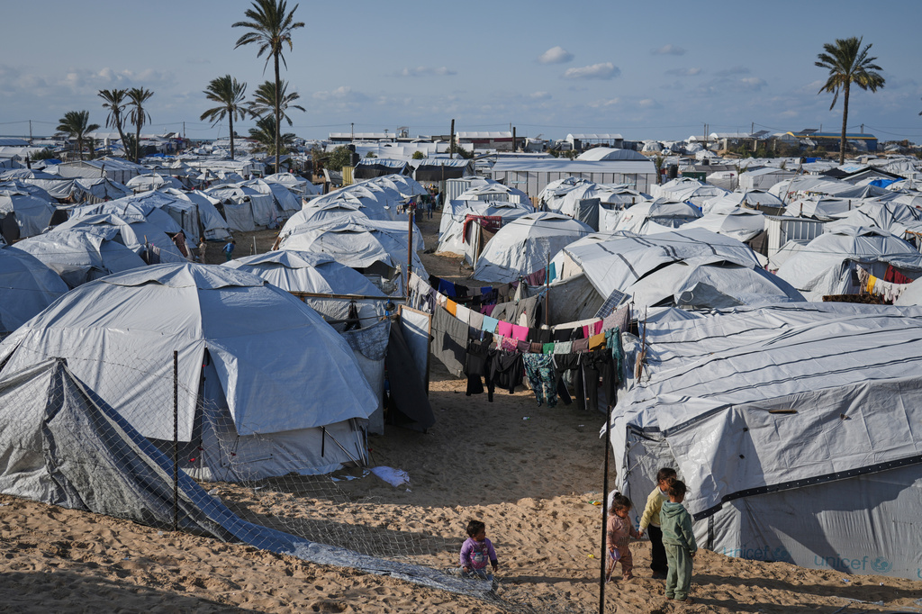 Palestinian children walk between tents at an orphanage camp in Khan Younis, southern Gaza Strip, Tuesday, Jan. 20, 2026. (AP Photo/Jehad Alshrafi)