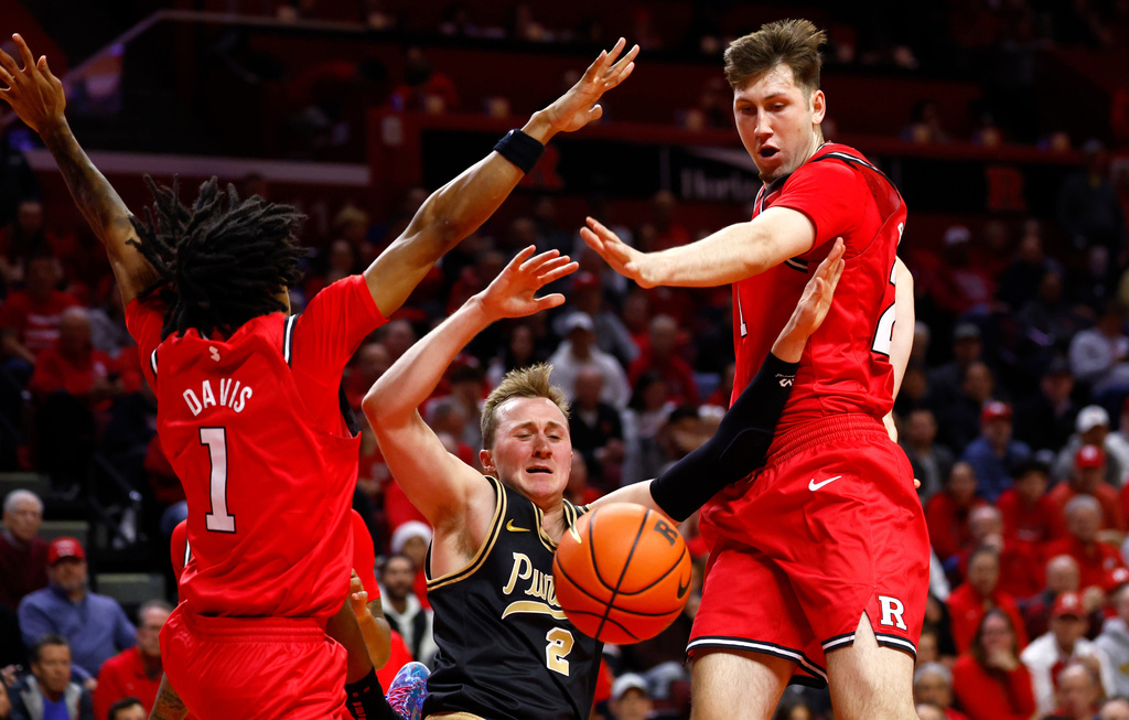 Purdue guard Fletcher Loyer (2) drives to the basket against Rutgers guard Jamichael Davis (1) and forward Denis Badalau (27) during the first half of an NCAA college basketball game, Tuesday, Dec. 2, 2025, in Piscataway, N.J. (AP Photo/Noah K. Murray)
