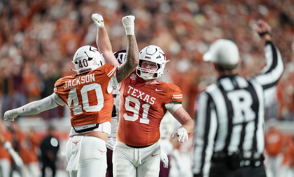 Texas defensive end Lance Jackson (40) and Texas defensive end Ethan Burke (91) celebrate a third down stop against Texas A&M Aggies during the first half of an NCAA college football game in the Lone Star Showdown in Austin, Texas, Friday, Nov. 28, 2025. (Ricardo B. Brazziell/Austin American-Statesman via AP)