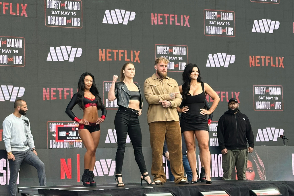 Ronda Rousey, center left, and Gina Carano, right, pose with promoter Jake Paul, center right, during a news conference in Inglewood, Calif., Tuesday, March 10, 2026. (AP Photo/Greg Beacham)