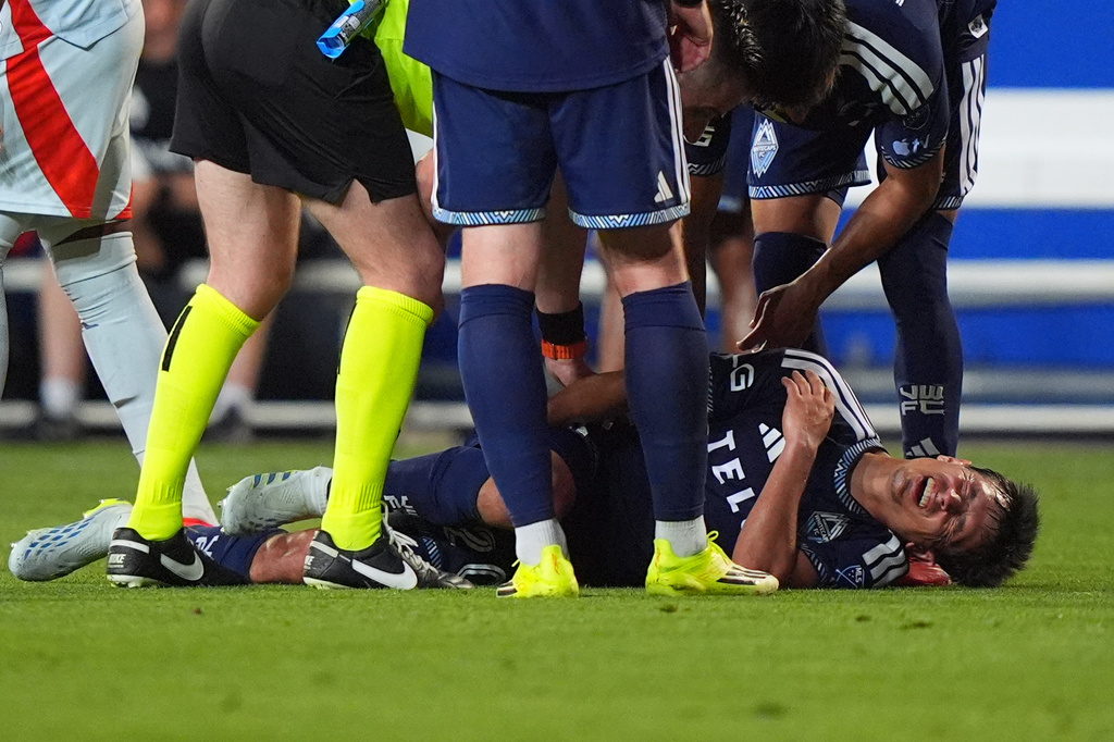Teammates check on Vancouver Whitecaps FC midfielder Andrés Cubas after he went down injured during the second half of an MLS soccer match against FC Dallas in Frisco, Texas, Wednesday, May 13, 2026. (AP Photo/LM Otero)