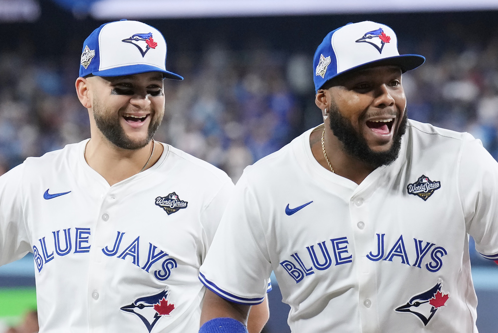 Toronto Blue Jays' Bo Bichette, left, and Vladimir Guerrero Jr. look on during player introductions ahead of the first inning in Game 1 of baseball's World Series, Friday, Oct. 24, 2025, in Toronto. (Nathan Denette/The Canadian Press via AP)