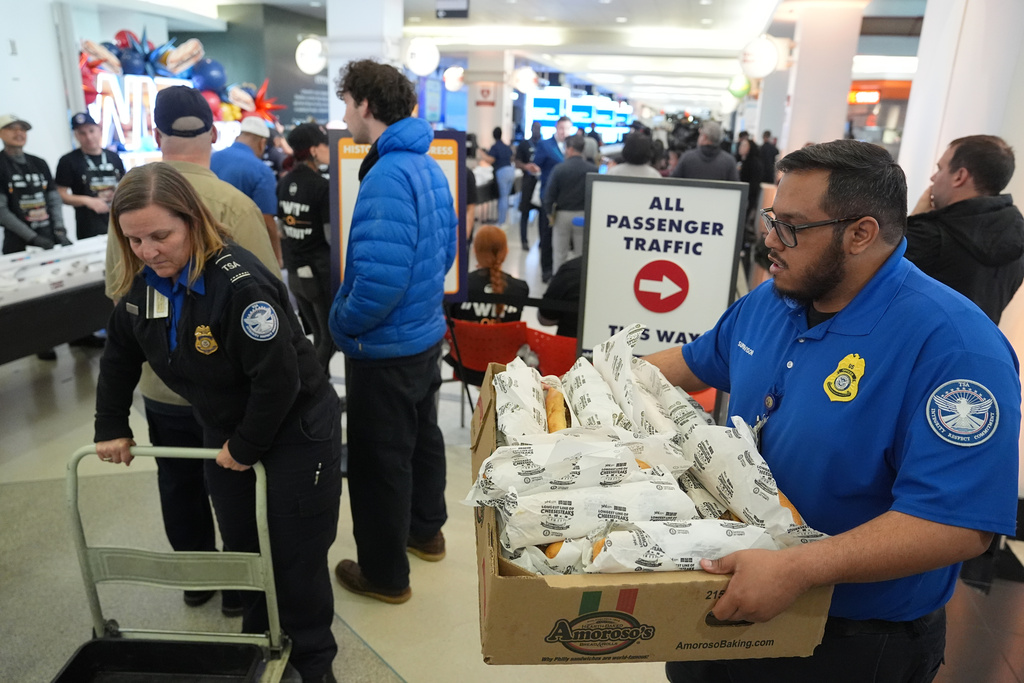 Transportation Security Administration (TSA) workers collect cheesesteaks for their coworkers that were made for a Guinness World Record attempt on National Cheesesteak Day at Philadelphia International Airport, Tuesday, March 24, 2026, in Philadelphia. (AP Photo/Matt Rourke)