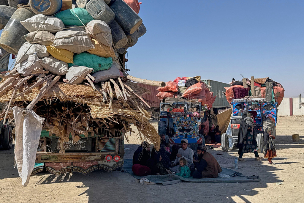Afghan refugees sit next to their belongings loaded onto vehicles as they wait for opening of the border crossing point, which closed following Afghan and Pakistani security forces exchanged cross border firing, at a camp in Chaman, Pakistan, Sunday, Oct. 12, 2025. (AP Photo)