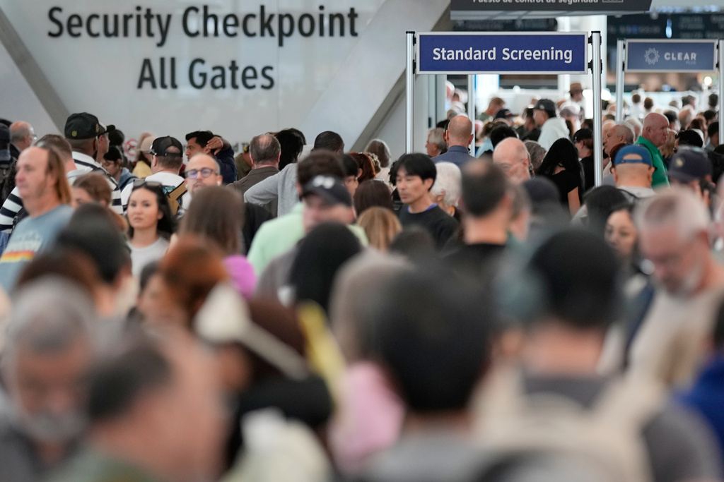 Passengers wait in a security checkpoint line at George Bush Intercontinental Airport, Wednesday, March 25, 2026, in Houston. (AP Photo/David J. Phillip)