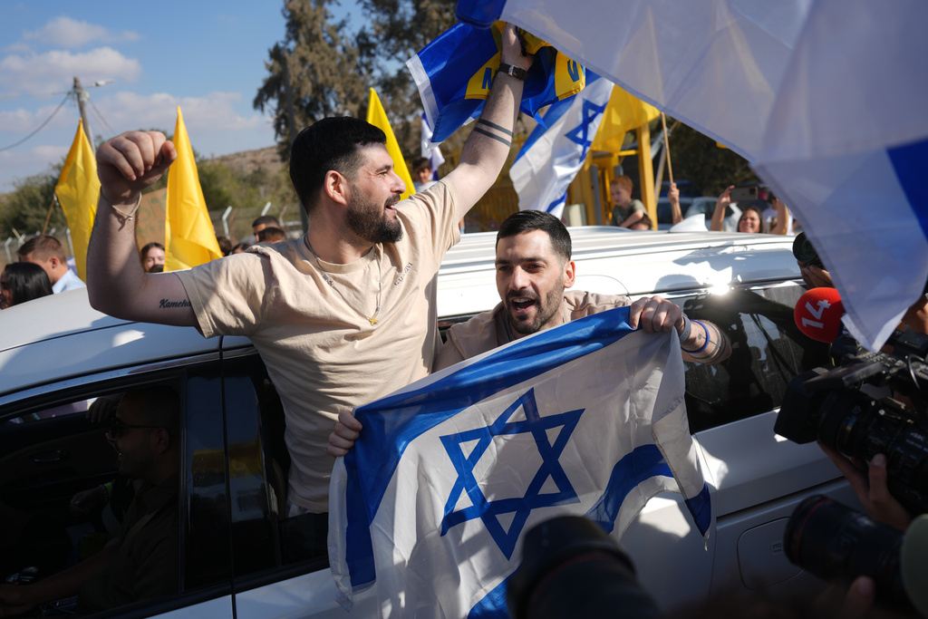 Freed Israeli hostages, twin brothers Gali and Ziv Berman, who were recently released from Hamas captivity in Gaza, are welcomed home as they return from the hospital to Kibbutz Beit Guvrin, Israel, on Sunday, Oct. 19, 2025. (AP Photo/Ariel Schalit)
