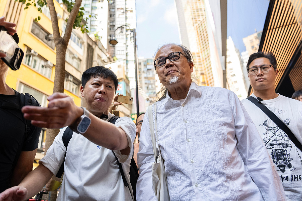 Police officers escort artist Sanmu Chen in the Causeway Bay area on the eve of the 37th anniversary of China's Tiananmen Square crackdown in Hong Kong, Wednesday, June 3, 2026. (AP Photo/Chan Long Hei)