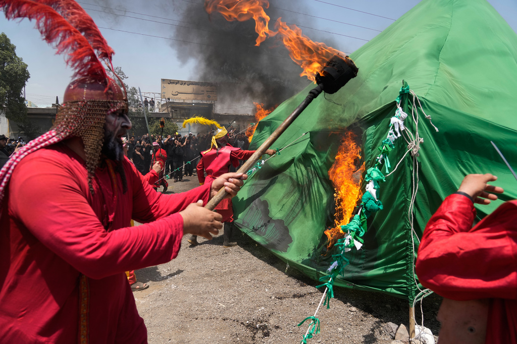 Men burn a tent in Tehran, Iran, Thursday, June 25, 2026, while re-enacting the enemies of Imam Hussein in the battle of Karbala in A.D. 680 in present-day Iraq, in which the Imam, a grandson of the Prophet Muhammad, one of Shiite Islam's most beloved saints, and his family and companions were killed after refusing to pledge allegiance to the Umayyad caliphate. (AP Photo/Vahid Salemi)