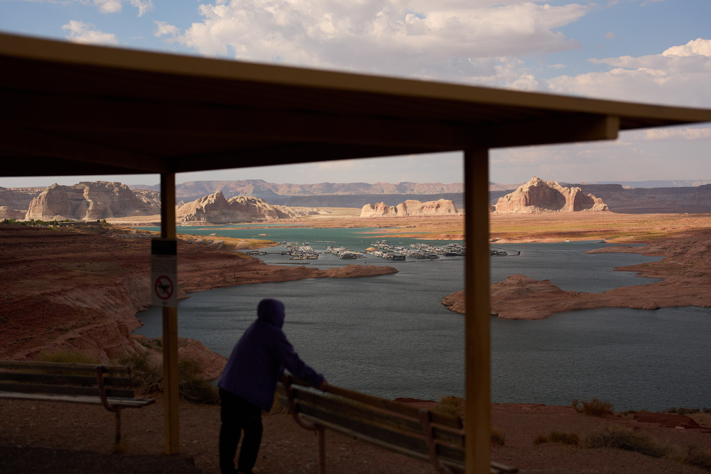 A person stands at an overlook near the Wahweap Marina on Lake Powell at the Glen Canyon National Recreation Area, Tuesday, July 14, 2026, near Page, Ariz. (AP Photo/John Locher)