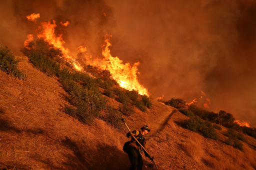 FILE - A firefighter battles the Palisades Fire in Mandeville Canyon, Jan. 11, 2025, in Los Angeles. (AP Photo/Jae C. Hong, File) FILE - A firefighter battles the Palisades Fire in Mandeville Canyon, Jan. 11, 2025, in Los Angeles. (AP Photo/Jae C. Hong, File)