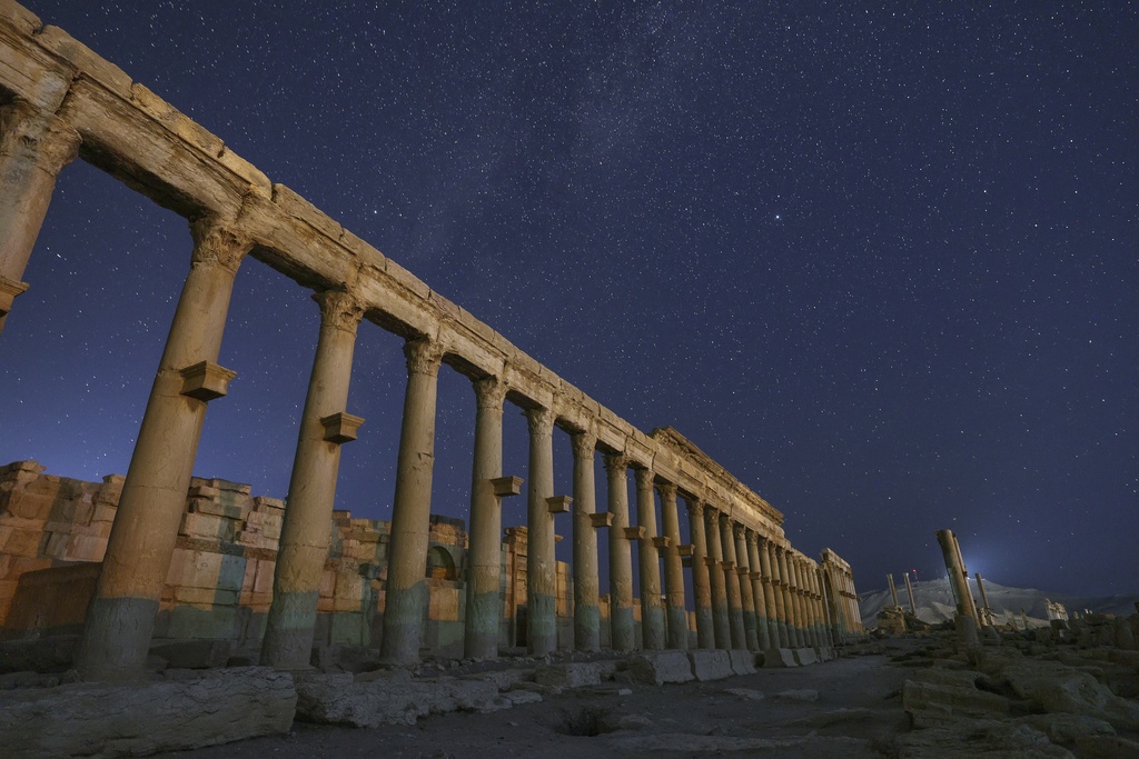 The colonnaded Long Street in the ruins of the ancient city of Palmyra is seen under a star-filled sky in Syria, early Wednesday, Aug. 27, 2025. (AP Photo/Ghaith Alsayed)