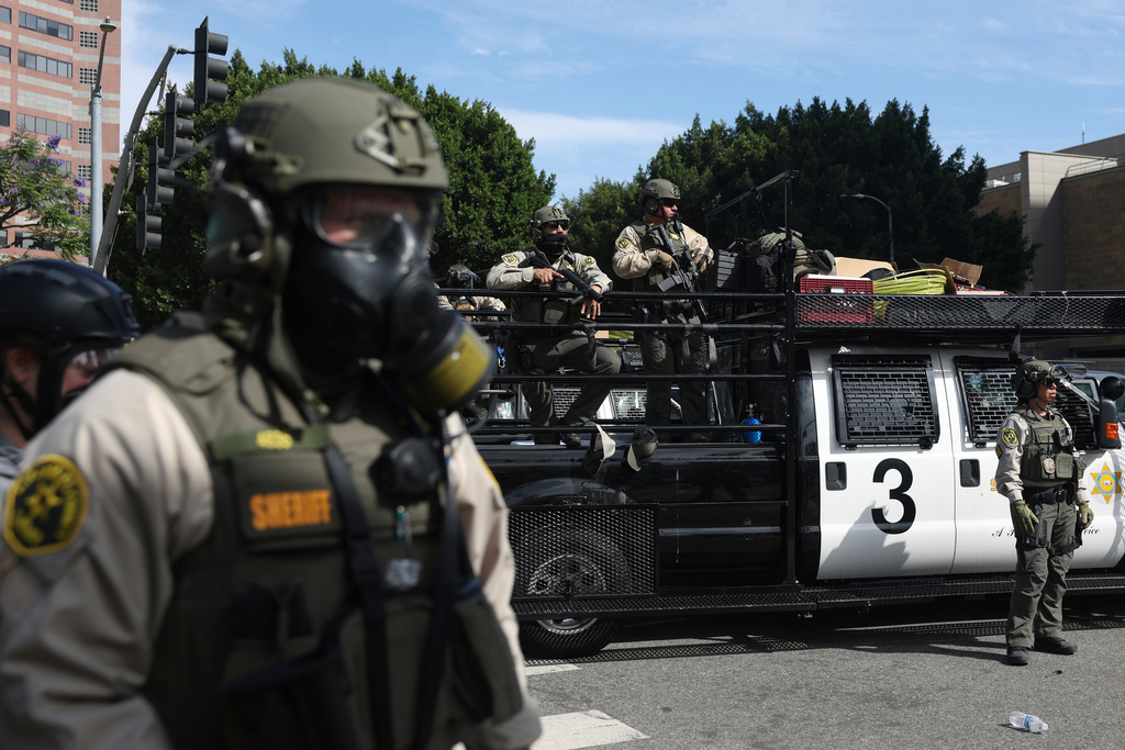 FILE - Law enforcement officers stand guard during a protest, June 14, 2025, in Los Angeles. (AP Photo/Ethan Swope, File)