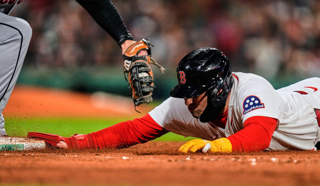 Boston Red Sox's Caleb Durbin dives back safely to first on a pick off attempt, beating a tag by Cleveland Guardians' David Fry, during the seventh inning of a baseball game, Thursday, Sept. 24, 2026, in Boston. (AP Photo/Charles Krupa)