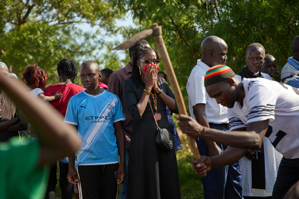 A family member grieves at the burial of a relative on the outskirts of Kisumu, Kenya, Friday, March 13, 2026. (AP Photo/Asa Wallin)