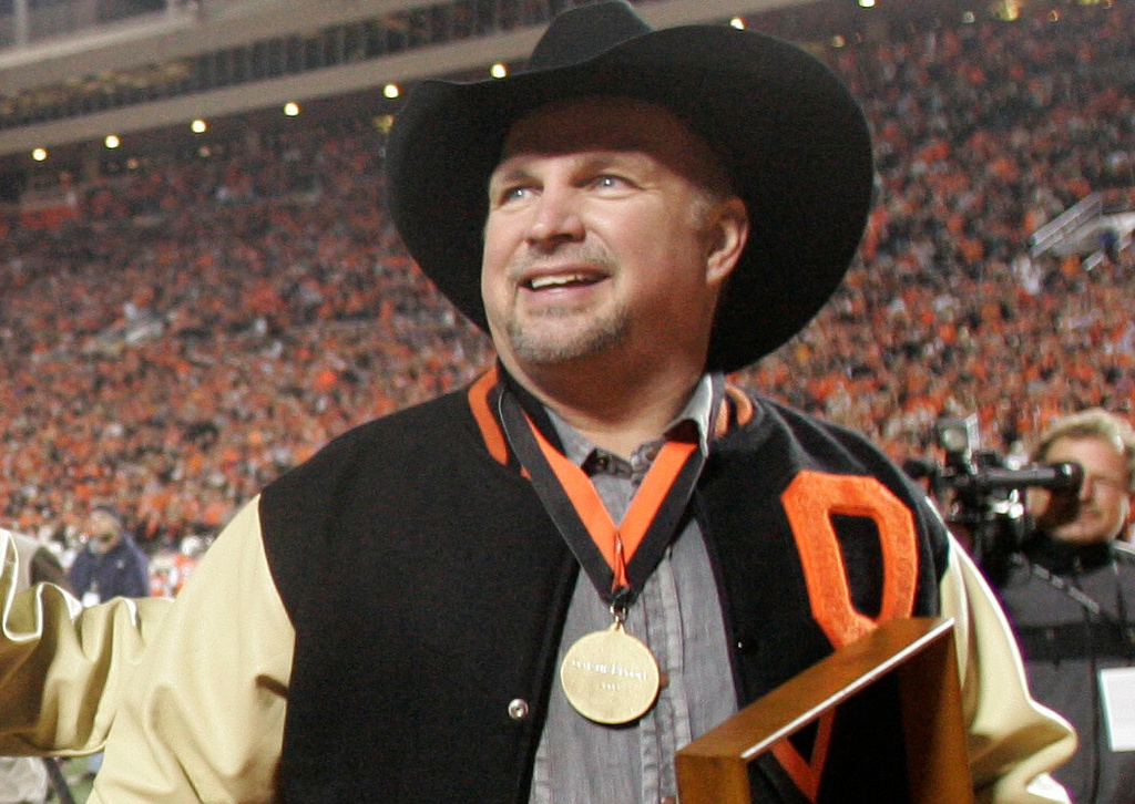 FILE - Oklahoma State alumn Garth Brooks walks off the field after being introduced to the crowd during the Missouri-Oklahoma State NCAA college football game in Stillwater, Okla., Saturday, Oct. 17, 2009. (AP Photo/Sue Ogrocki, File)