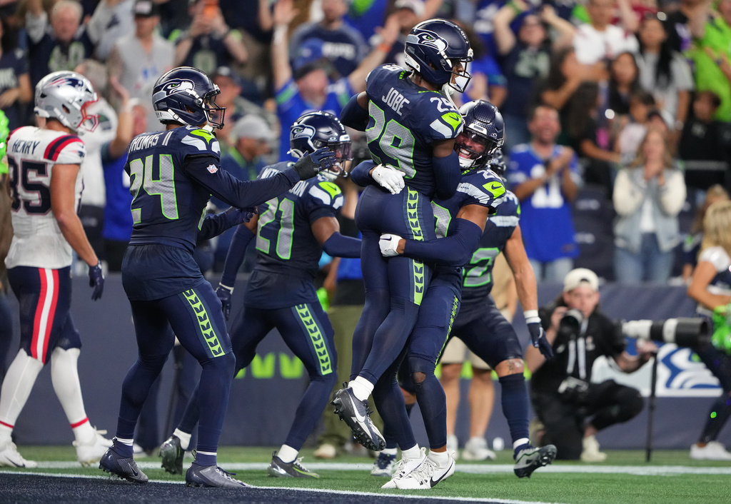 Seattle Seahawks cornerback Josh Jobe, top right, is lifted by safety Julian Love as they celebrate Jobe's interception in the end zone during the second half of an NFL football game against the New England Patriots, Wednesday, Sept. 9, 2026, in Seattle. (AP Photo/Lindsey Wasson)