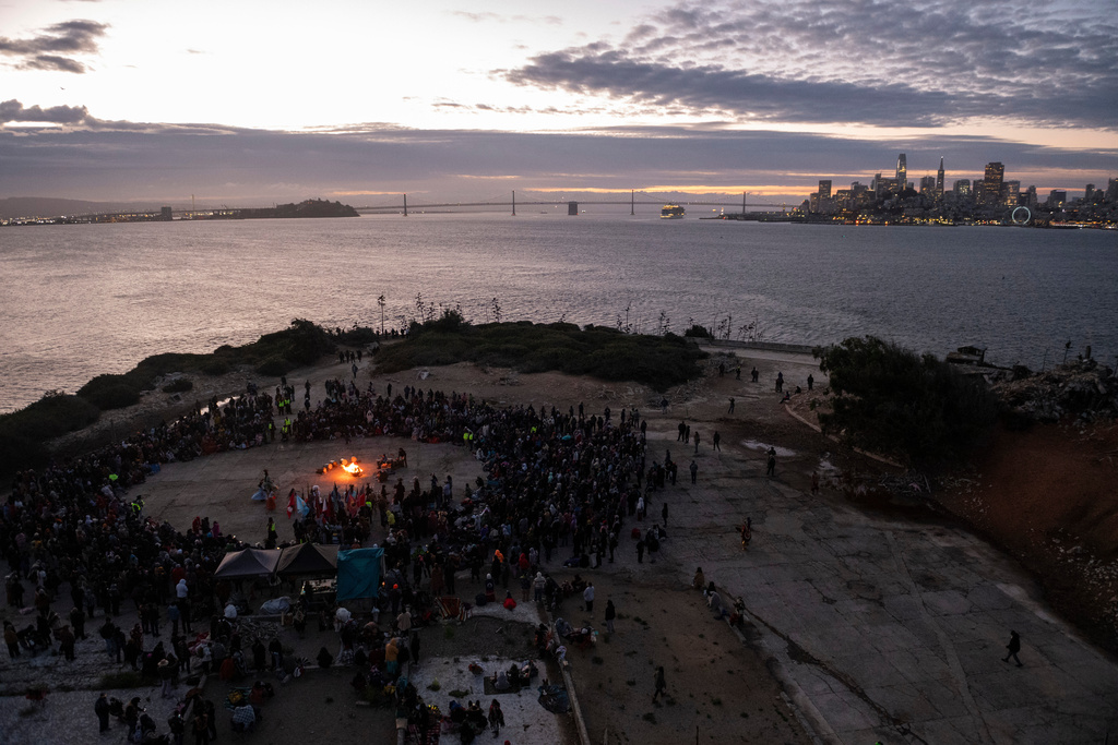 People attend a sunrise gathering during Indigenous Peoples Day on Alcatraz Island on Monday, Oct. 13, 2025, in San Francisco. (AP Photo/Laure Andrillon)