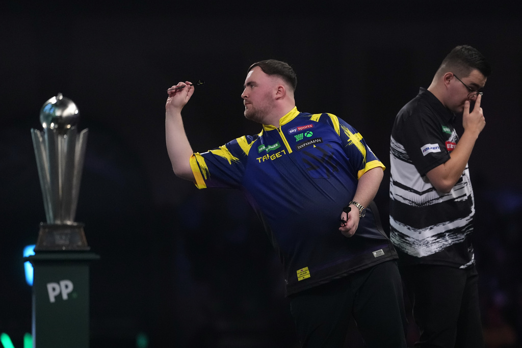 England's Luke Littler throws a dart during the World Darts Championships final match against Gian van Veen of the Netherlands at Alexandra Palace in London, Saturday, Jan. 3, 2026.(AP Photo/Dave Shopland)