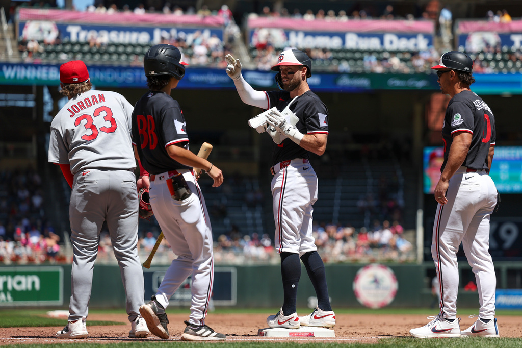 Minnesota Twins' Kody Clemens, third from left, reacts after hitting a single during the third inning of a baseball game against the St. Louis Cardinals, Sunday, June 14, 2026, in Minneapolis. (AP Photo/Ellen Schmidt)