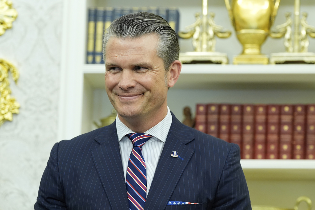 Defense Secretary Pete Hegseth listens as President Donald Trump speaks during an event signing a proclamation honoring the fourth anniversary of the attack at Abbey Gate in Afghanistan, in the Oval Office of the White House, Monday, Aug. 25, 2025, in Washington. (AP Photo/Alex Brandon)