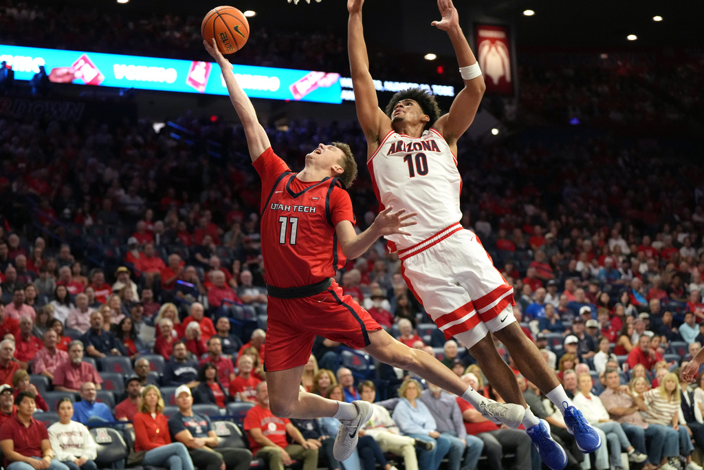 Utah Tech guard Tanner Davis (11) drives past Arizona forward Koa Peat (10) during the first half of an NCAA college basketball game Friday, Nov. 7, 2025, in Tucson, Ariz. (AP Photo/Rick Scuteri)