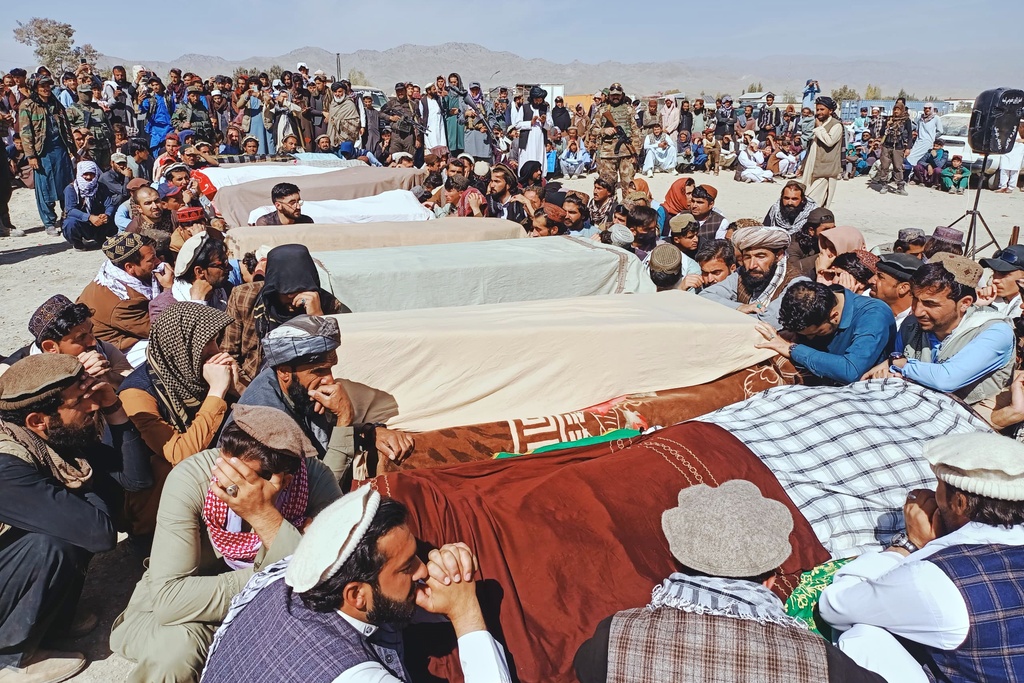 Local residents pray over the bodies of victims of a Pakistani cross-border airstrike, including three local cricketers, during a funeral in the village of Khandaro in the Argun district of Afghanistan's eastern Paktika province, Saturday, Oct. 18, 2025. (AP Photo/Shafiqullah Mashaal)