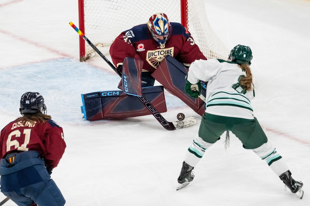 Montreal Victoire goaltender Ann-Renee Desbiens, top, makes a save against Boston Fleet's Haley Winn (8) during third-period PWHL hockey game action in Laval, Quebec, Friday, April 17, 2026. (Christopher Katsarov/The Canadian Press via AP)