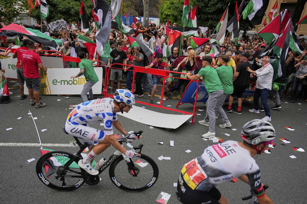 People hold Palestinian flags as they try to disrupt the eleventh stage of the Spanish Vuelta cycling race, from Bilbao to Bilbao, Spain, Wednesday, Sept. 3, 2025. (AP Photo/Miguel Oses)