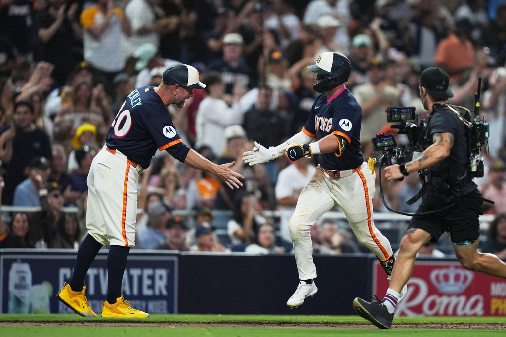 San Diego Padres' Jase Bowen, right, celebrates with third base coach Bob Henley after hitting a home run during the fourth inning of a baseball game against the San Francisco Giants Friday, July 31, 2026, in San Diego. (AP Photo/Gregory Bull)
