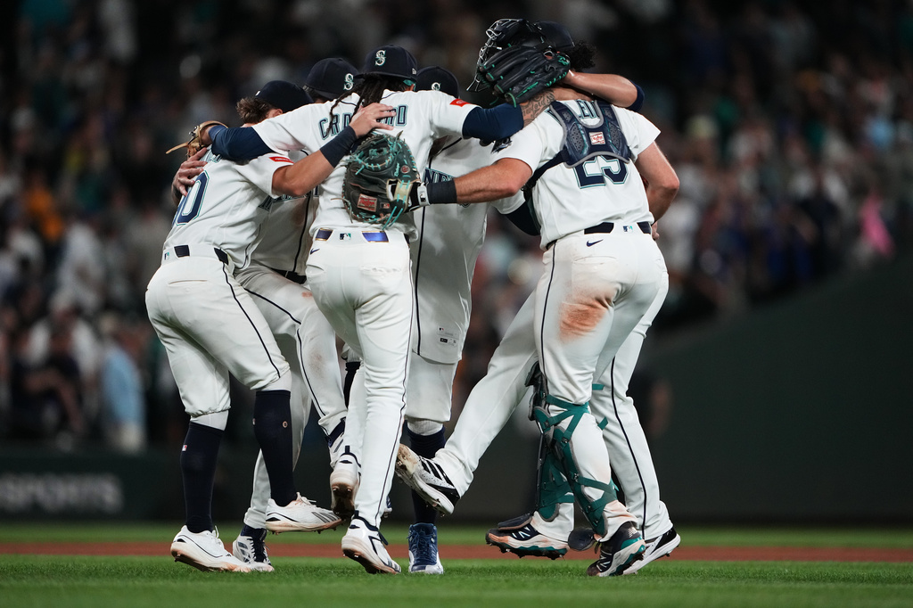 The Seattle Mariners infield, including shortstop J.P. Crawford (3) and catcher Cal Raleigh (29) celebrate a win over the Philadelphia Phillies in a baseball game, Tuesday, Aug. 25, 2026, in Seattle. (AP Photo/Lindsey Wasson)