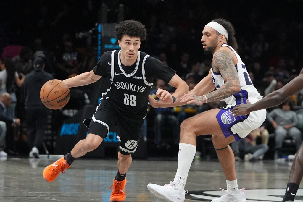 Brooklyn Nets' Nolan Traore (88) drives past Sacramento Kings' Devin Carter (22) during the second half of an NBA basketball game Sunday, March 29, 2026, in New York. (AP Photo/Frank Franklin II)