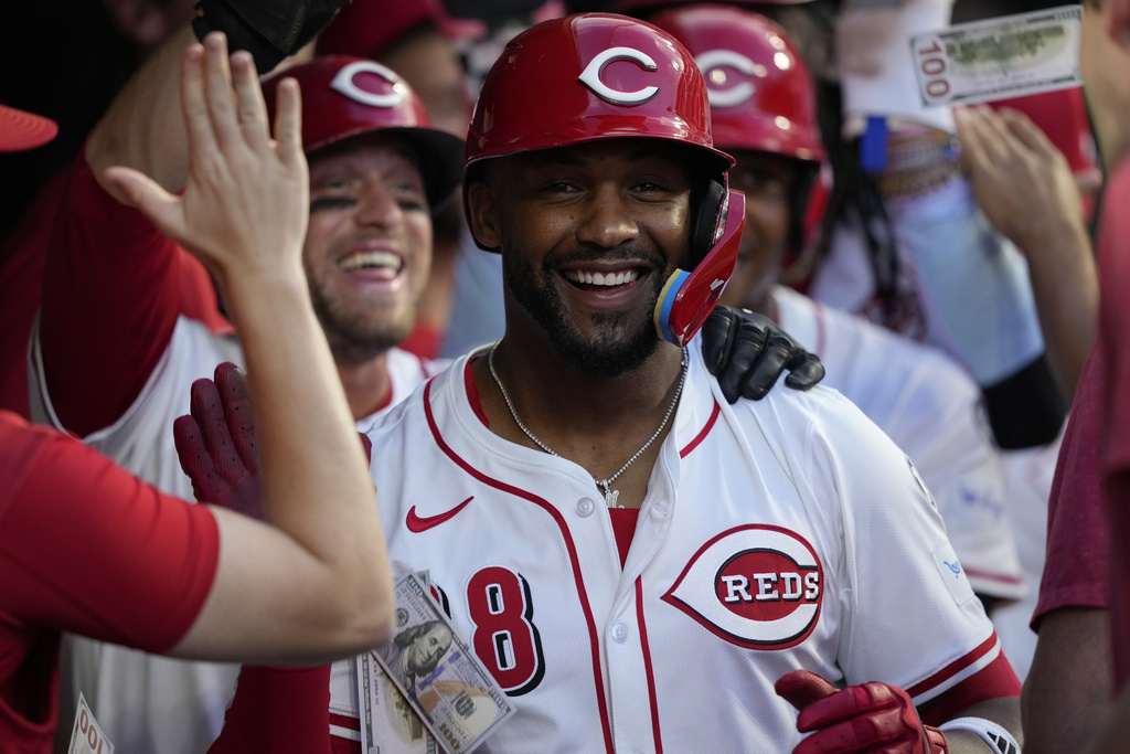 Cincinnati Reds' Miguel Andujar celebrates in the dugout after hitting a grand slam home run during the seventh inning of a baseball game against the Philadelphia Phillies Wednesday, Aug. 13, 2025, in Cincinnati. (AP Photo/Carolyn Kaster)