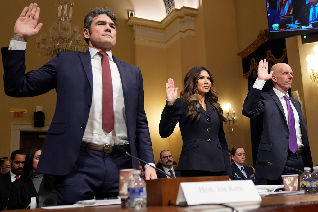 FILE - From left, Joseph Kent, director of the National Counterterrorism Center, Homeland Security Secretary Kristi Noem, and Michael Glasheen, operations director of the National Security Branch of the FBI, raise their arms before the House Committee on Homeland Security on Capitol Hill in Washington, Dec. 11, 2025. (AP Photo/Mark Schiefelbein, File)
