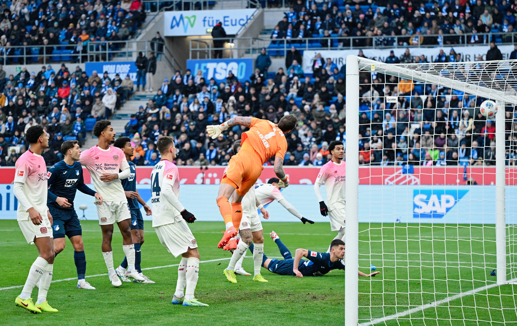 Leverkusen's goalkeeper Mark Flekken, centre, misses the opening goal by Hoffenheim's Wouter Burger during the German Bundesliga soccer match between TSG 1899 Hoffenheim and Bayer Leverkusen in Sinsheim, Germany, Saturday, Jan. 17, 2026. (Uwe Anspach/dpa via AP)