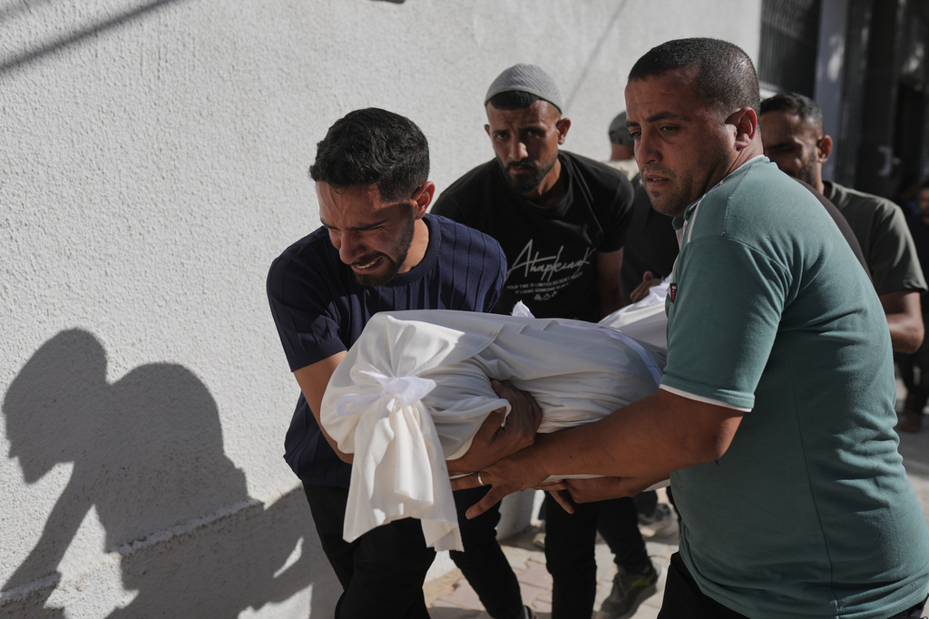 Relatives carry the body of Shadi Abu Sweilem, who was killed in an Israeli airstrike, during his funeral at Al-Shifa Hospital in Gaza City Sunday, June 14, 2026. (AP Photo/Jehad Alshrafi)
