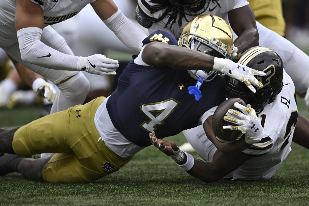 Notre Dame running back Jeremiyah Love (4) rushes near the goal line against Purdue's Tahj Ra-El (21) during the first quarter of an NCAA football game Saturday, Sept. 20, 2025, in South Bend, Ind. (AP Photo/Paul Beaty)