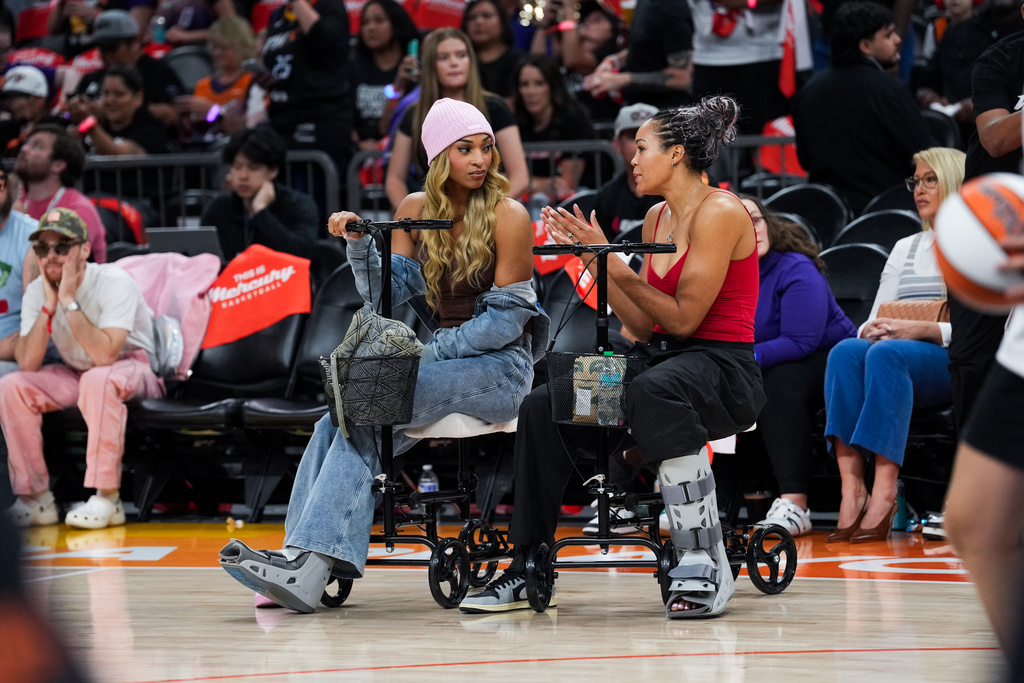 Minnesota Lynx guard DiJonai Carrington (left) and forward Napheesa Collier (24) are out for Game 4 of a WNBA basketball playoff semifinals series against the Phoenix Mercury, Sunday, Sept. 28, 2025, in Phoenix. (AP Photo/Samantha Chow)