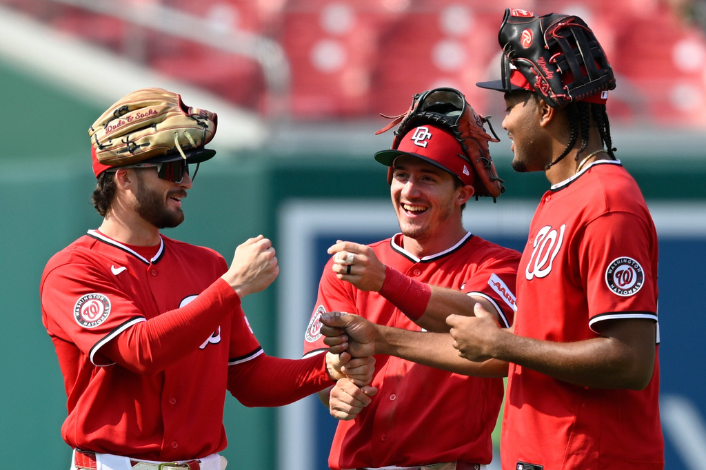 Washington Nationals left fielder Dylan Crews, left, center fielder Jacob Young, center, and right fielder James Wood, right, celebrate after their team's victory over the Arizona Diamondbacks in a baseball game, Sunday, July 26, 2026, in Washington. (AP Photo/John McDonnell)
