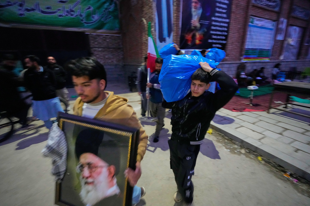 A boy carries a plastic bag of donated items collected during a relief drive for Iran in Budgam, Indian-controlled Kashmir, Monday, March 23, 2026. (AP Photo/Mukhtar Khan)
