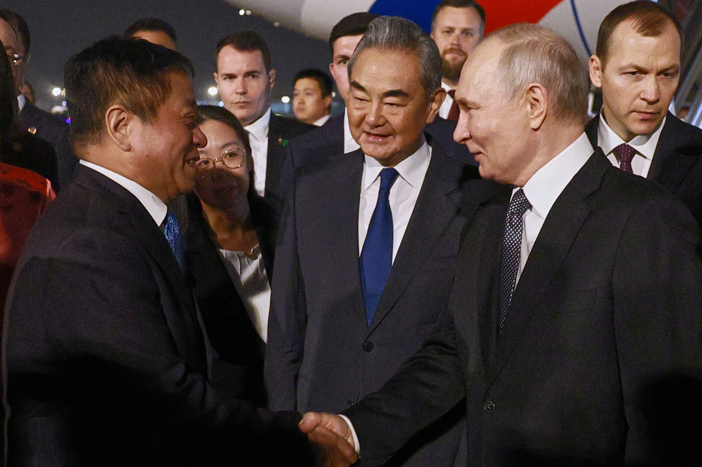 Chinese Ambassador to Russia Zhang Hanhui, left, and Chinese Foreign Minister Wang Yi, center, greet Russian President Vladimir Putin, right, as he arrives in Beijing, Tuesday, May 19, 2026. (Vladimir Smirnov, Sputnik, Kremlin Pool Photo via AP)